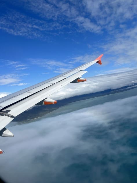 飛行機の窓から尾翼と空を撮影している。