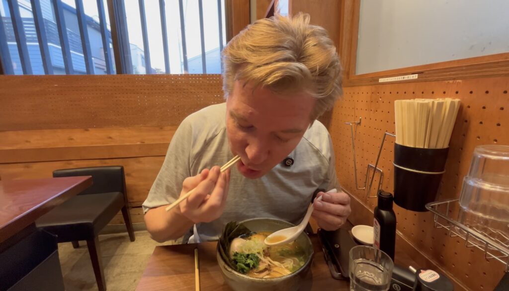 Australian man eating japanese food ramen in Japan