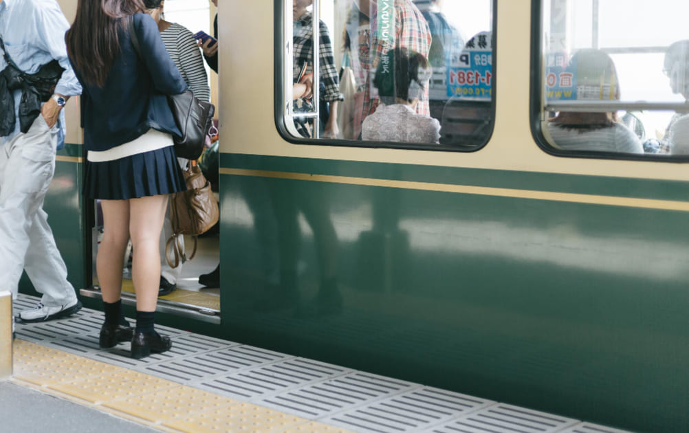 ダイヤ通りに到着した電車に乗ろうとしている女子高生。