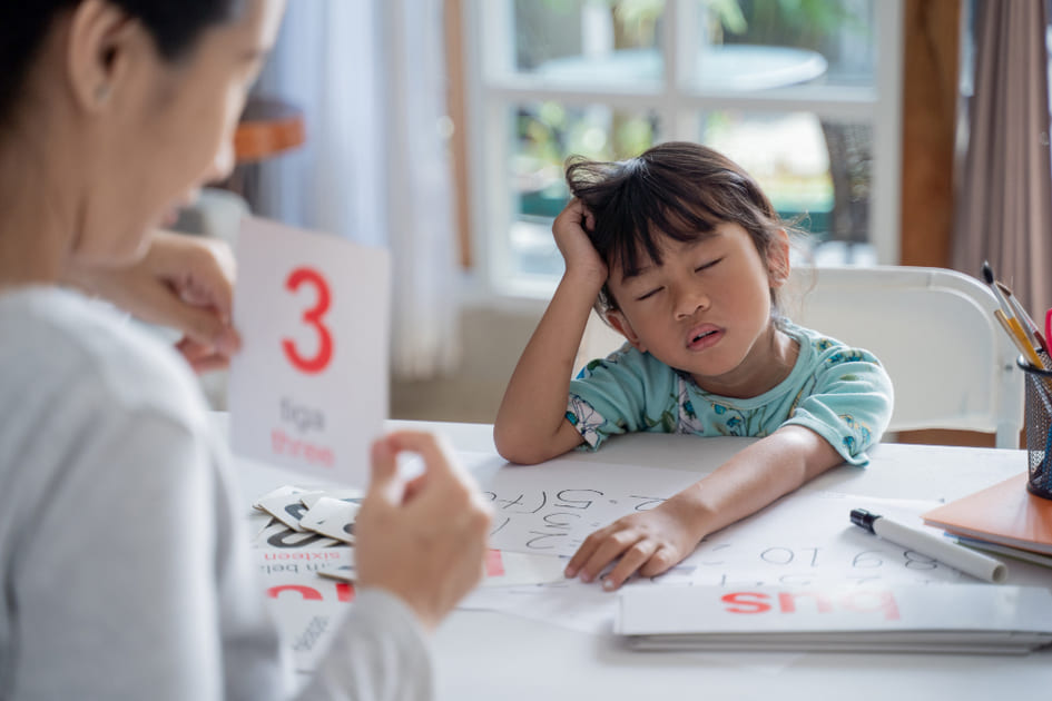 母親が幼い子供に熱心に学習をサポートしている。
