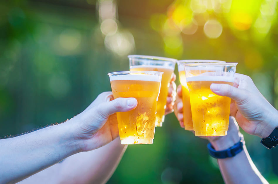ビールを片手に乾杯をする人々の手。