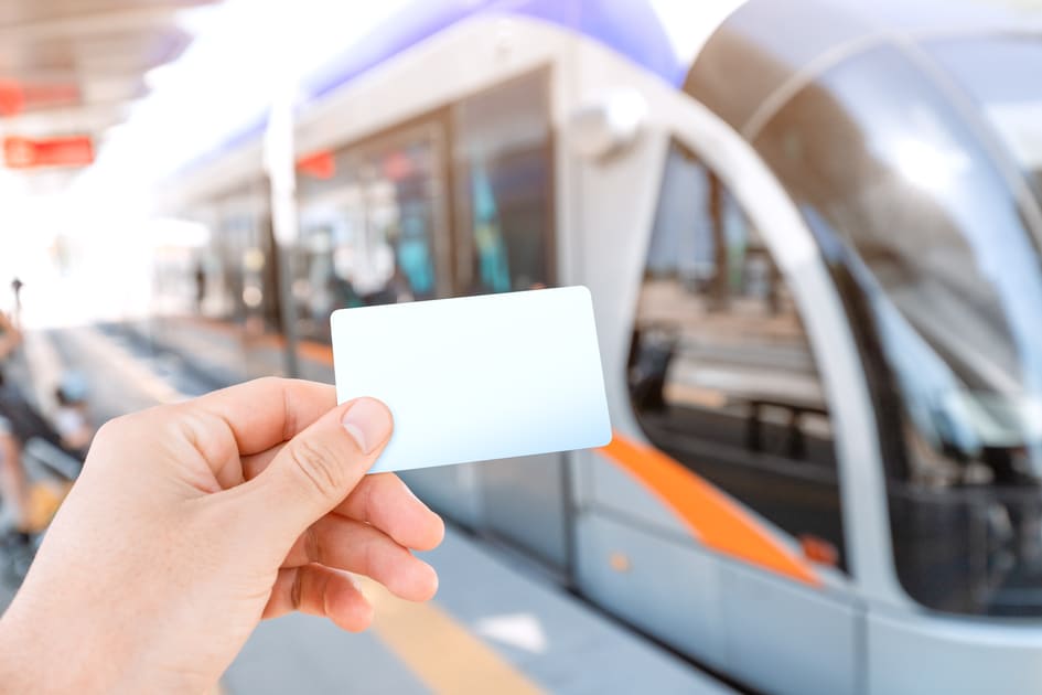 電車の前でICカードを持つ人。