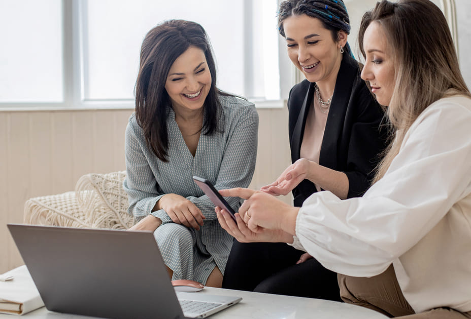 3人のキャリアウーマンが和やかに打ち合わせをしている。