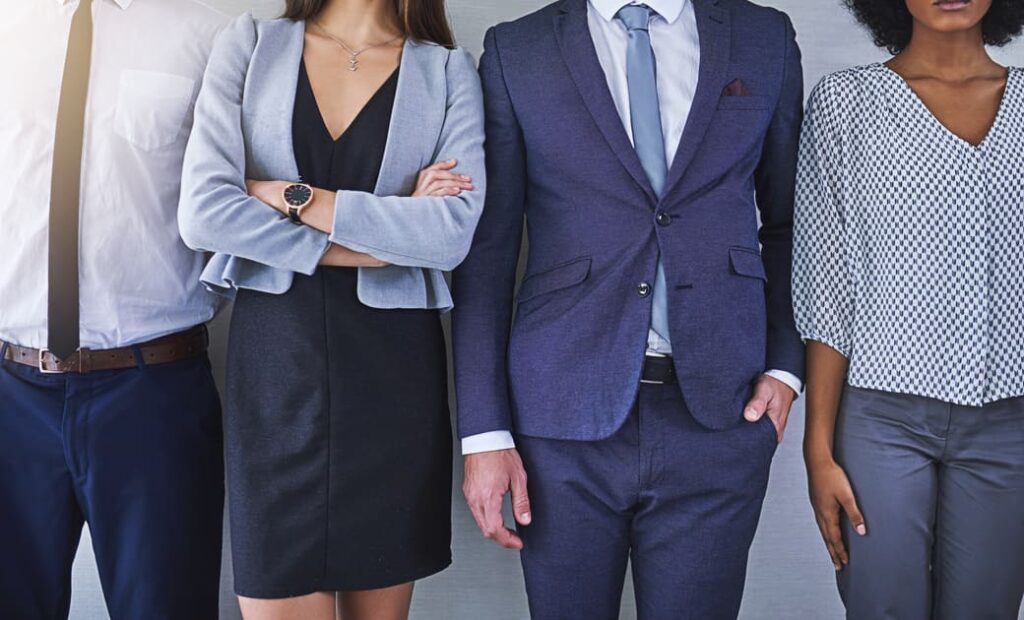 スーツを着てポーズを決める男女のビジネスマンたち。