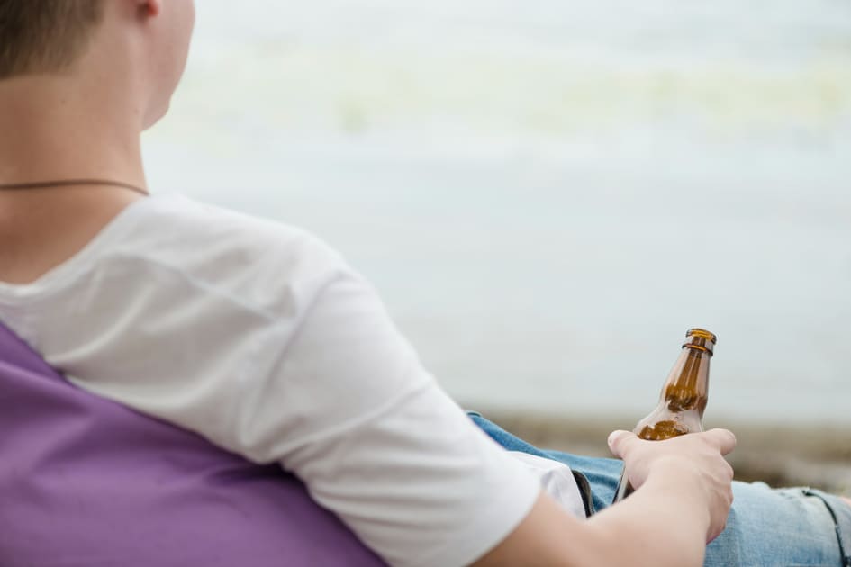 オーストラリアのビーチで瓶ビールを飲む男性はマナー違反。