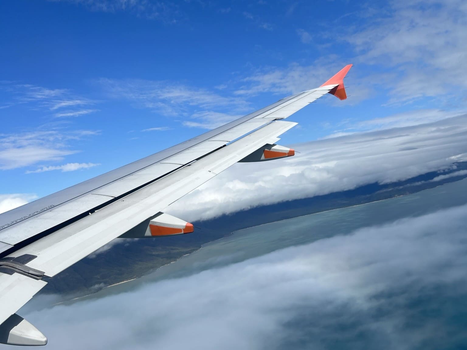 雲の上を飛ぶ飛行機の尾翼。