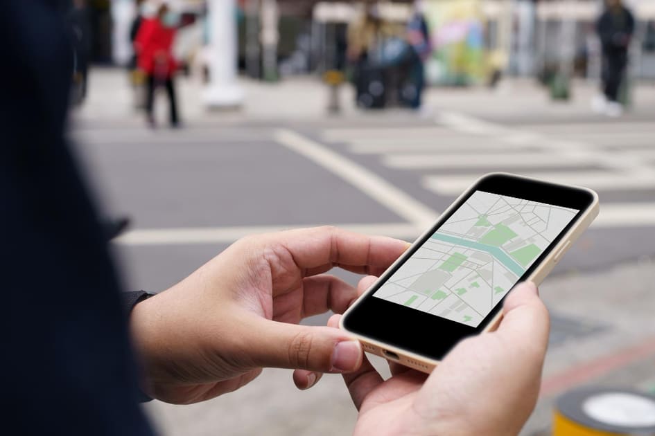 スマホの地図アプリで場所を確認している学生。