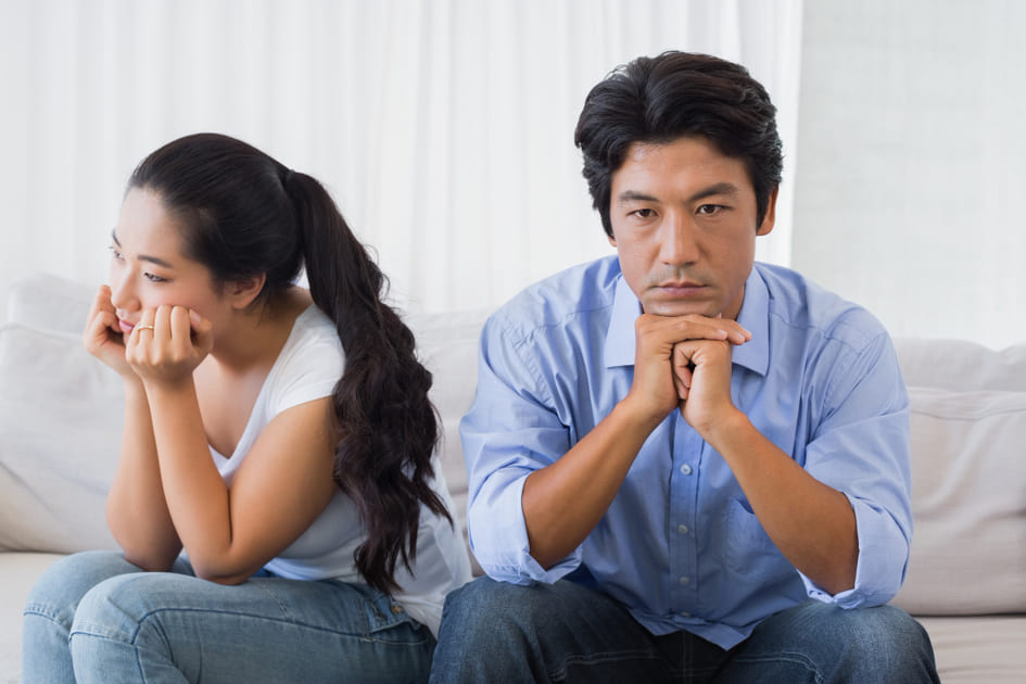 性格の不一致で会話がない、ソファに座る夫婦