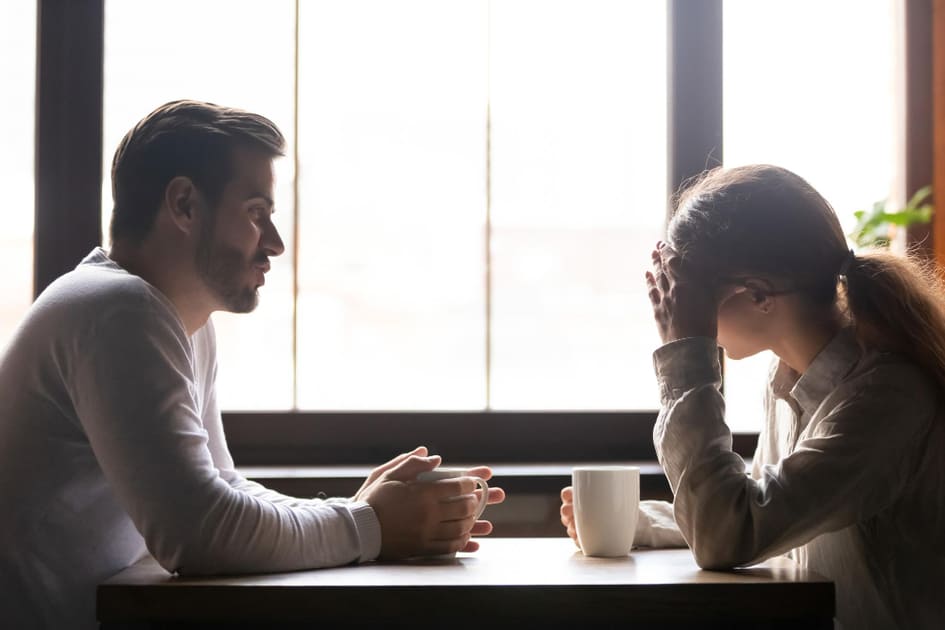 向き合って話し合い、問題と真摯に向き合うカップル